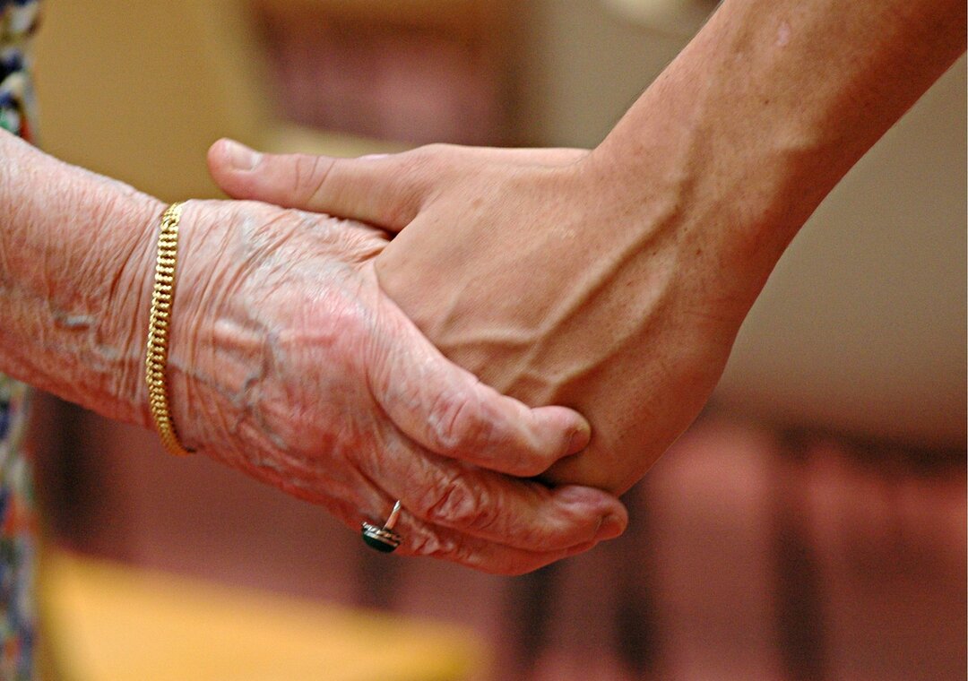Billedet viser to personer, der holder i hånd.