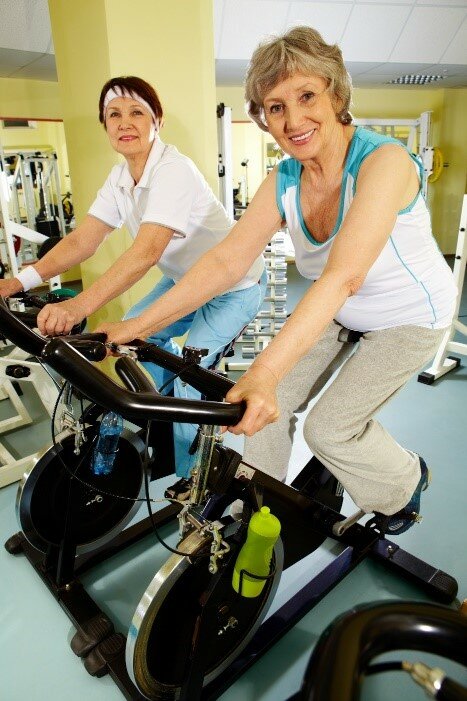 Billede af to kvinder på motionscykel