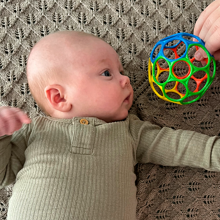 Baby ligger på ryggen og kigger til venstre