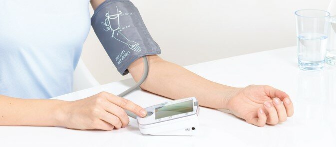 Billede af en arm med blodtryksmåler på.