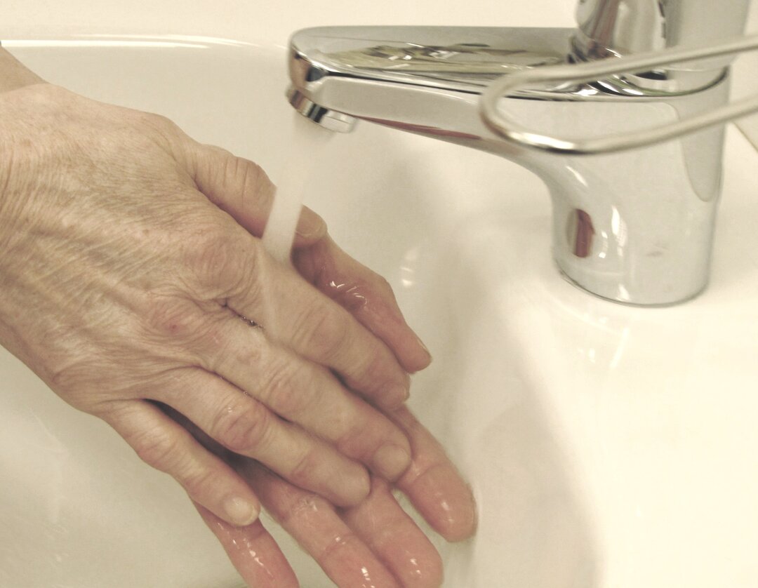 Et billede af en person, der vasker hænder. 