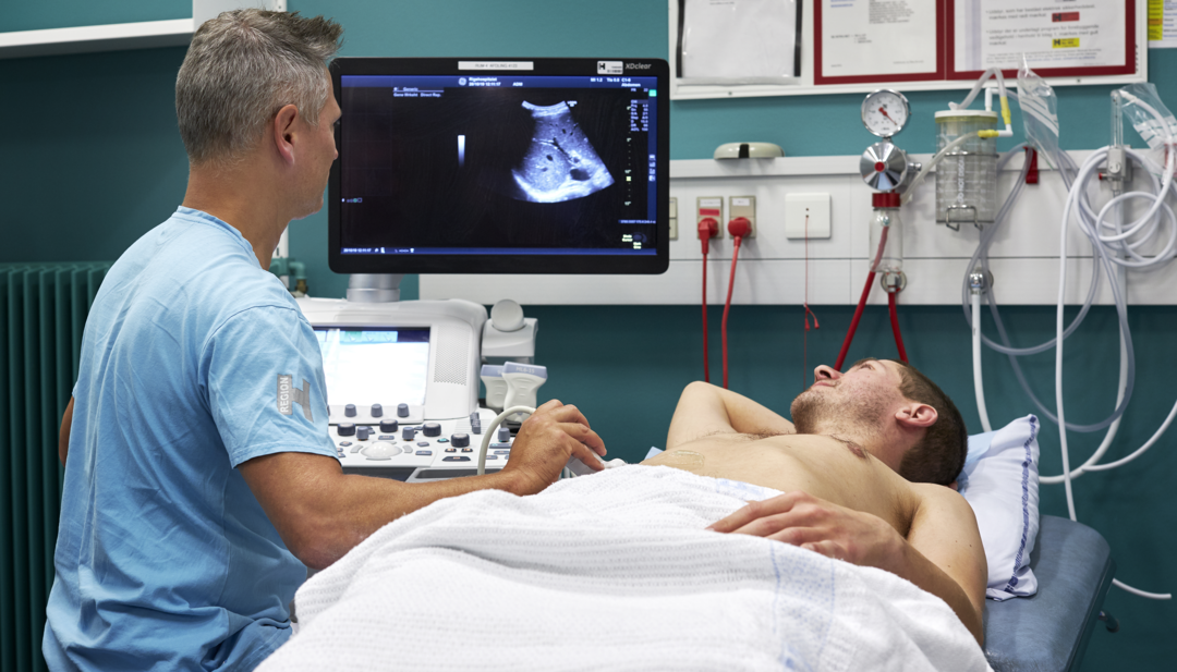 Billedet viser en læge, der ultralydsskanner en patient