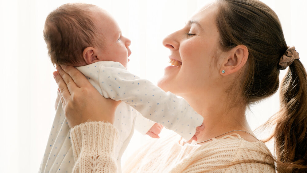 Kvinde holder og smiler til baby