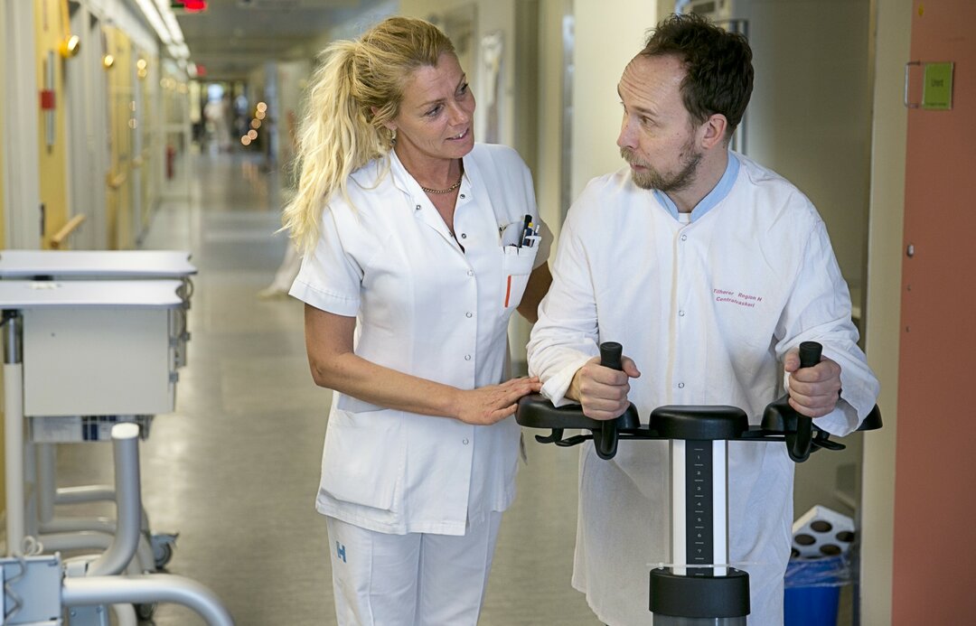 Billedet viser en patient genoptræne med hjælp fra en sygeplejersker.