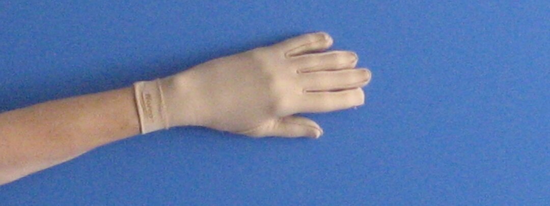 Billedet viser en tyk hvid handske på en hånd.