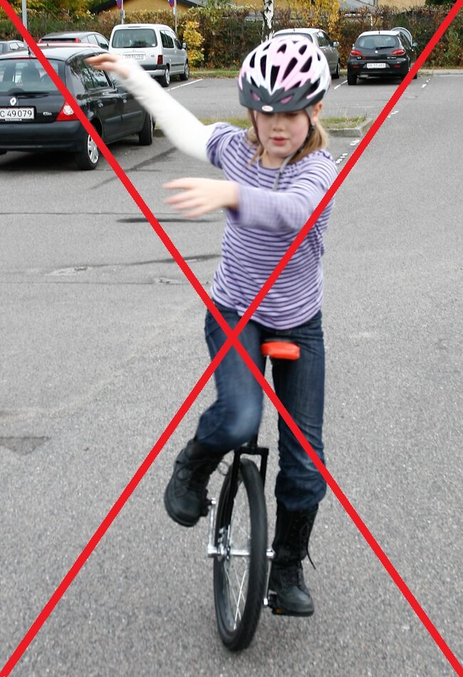 Billedet viser et barn på en ethjulet cykel med kryds over