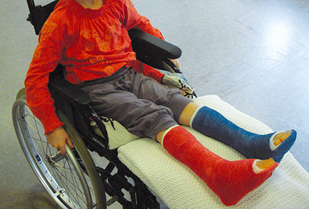 Billedet viser et barn i kørestol.
