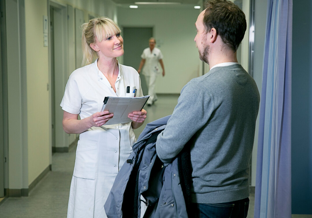 Billedet viser en patient og en sygeplejerske.