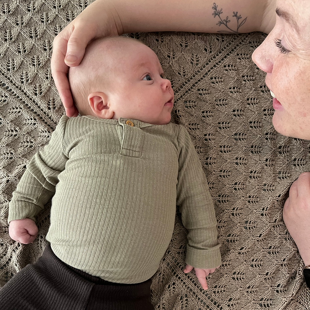 Baby ligger på ryggen med hovedet til venstre