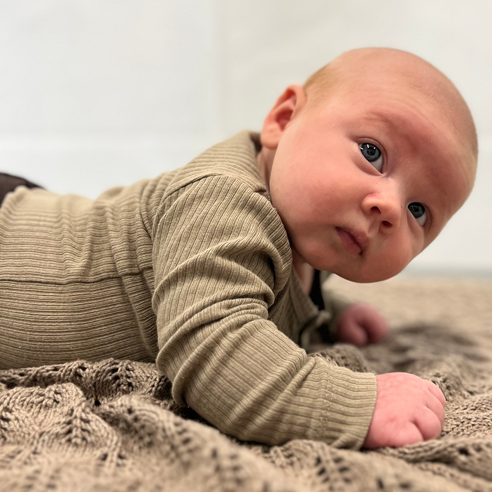 Baby ligger på maven med hovedet mod højre