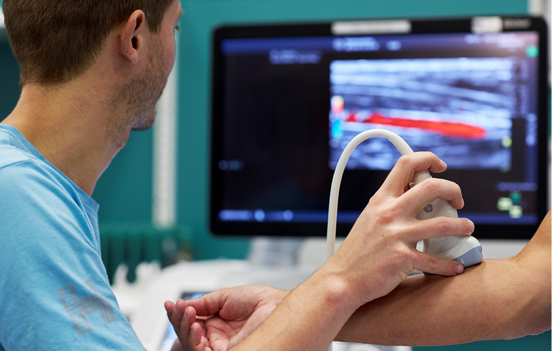 Billede af en patient, der får ultralydsskannet sin arm.