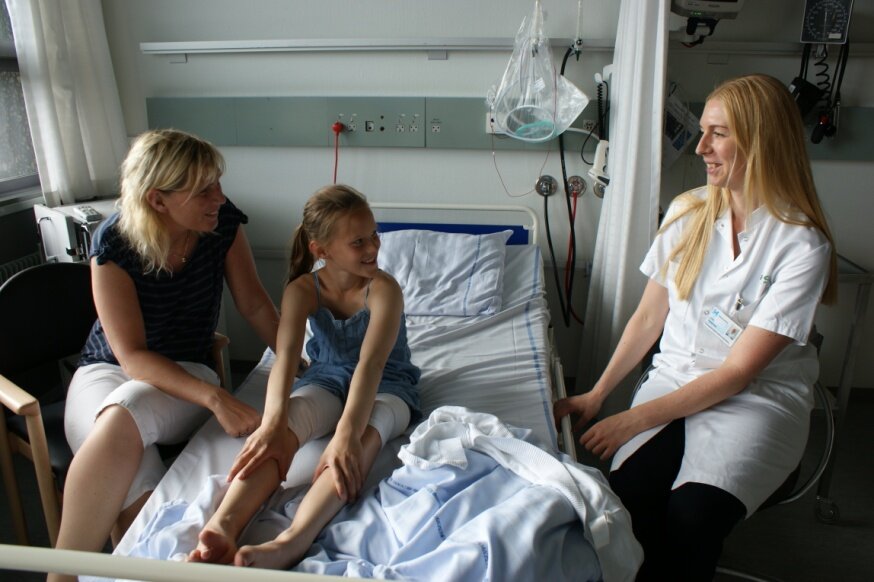 Patient, pårørende og sygeplejerske på sengestue