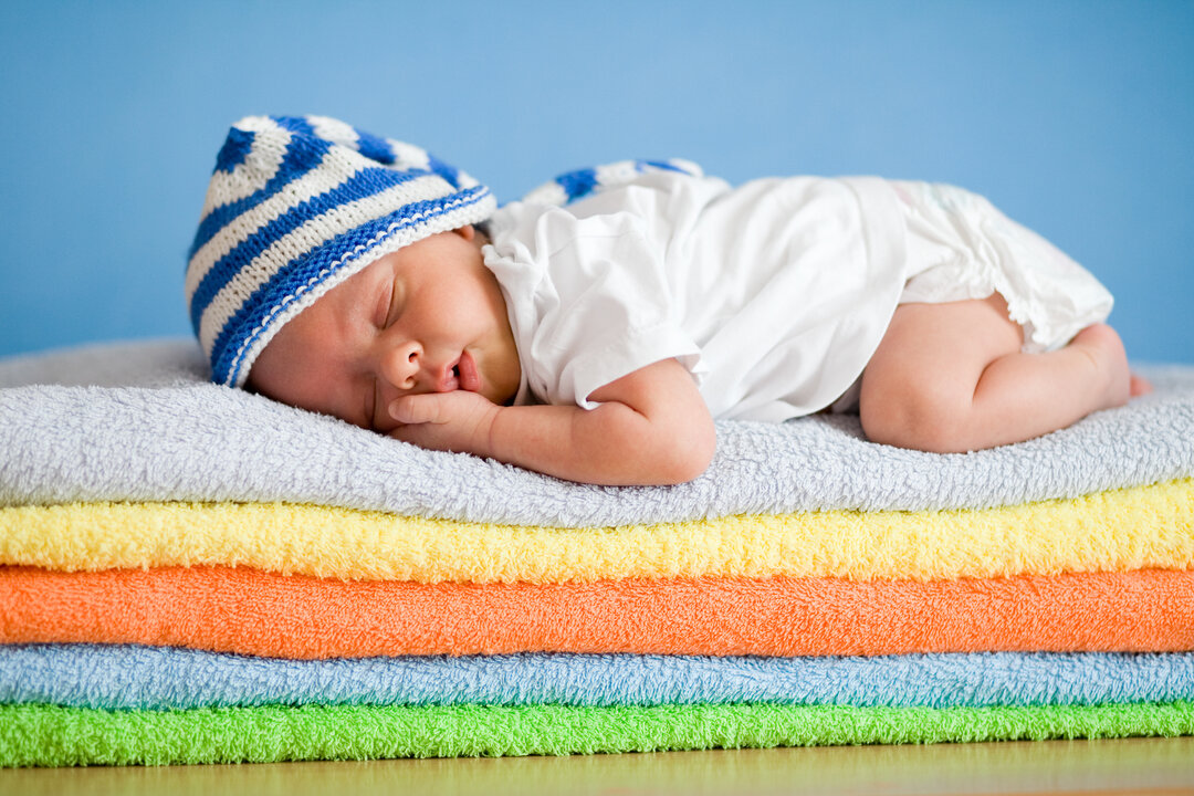 Billede af en baby, der sover på håndklæder.