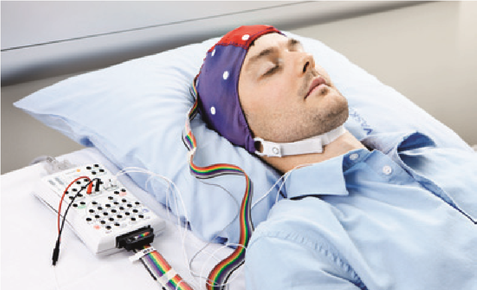 Sengeliggende patient med elektroder og hue