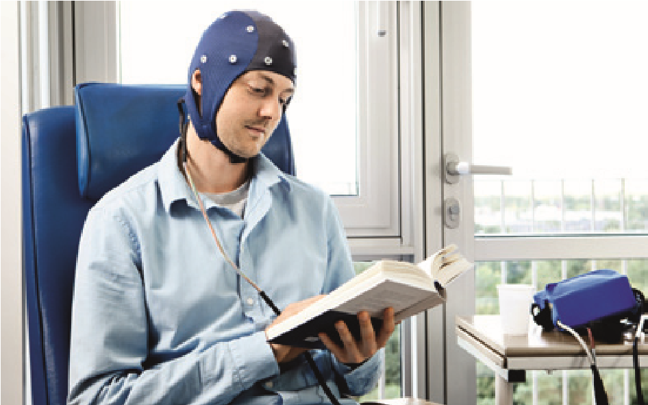Siddende patient med elektroder og hue