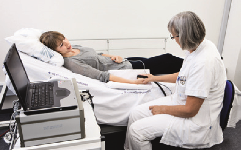 Sygeplejerske udfører termotest på sengeliggende patient