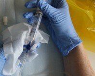 Hænder med handsker holder pumpe